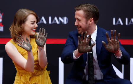 Actors Emma Stone and Ryan Gosling show their hands after placing them in cement during a ceremony in the forecourt of the TCL Chinese theatre in Hollywood, California U.S., December 7, 2016. REUTERS/Mario Anzuoni