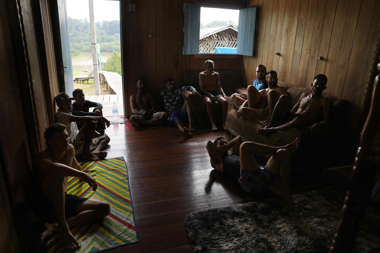Youth fishermen watch a soccer game on the tv in San Raimundo, in Carauari, Brazil, Sunday, Sept. 4, 2022. Thirty-four families call the area home. (AP Photo/Jorge Saenz)