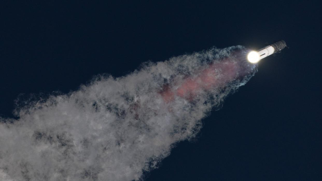  A massive rocket lifts off above a plume of fire at sunrise. 