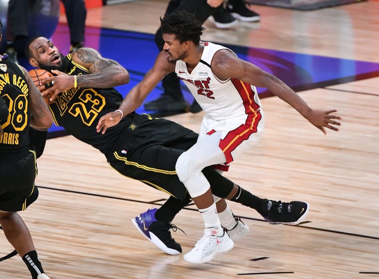 ORLANDO, FLORIDA OCTOBER 9, 2020-Lakers LeBron James collides with Heat's Jimmy Butler in the 4th quarter in Game 5 of the NBA FInals in Orlando Friday. (Wally Skalij/Los Angeles Times)