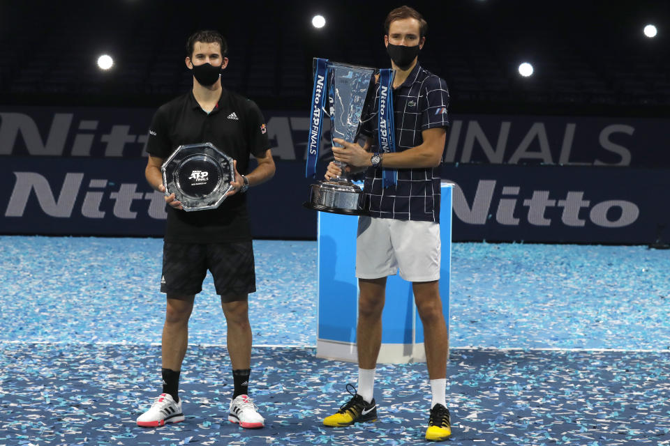 Daniil Medvedev of Russia, right, holds up the winners trophy after defeating Dominic Thiem of Austria, left, in the final of the ATP World Finals tennis match at the ATP World Finals tennis tournament at the O2 arena in London, Sunday, Nov. 22, 2020. (AP Photo/Frank Augstein)
