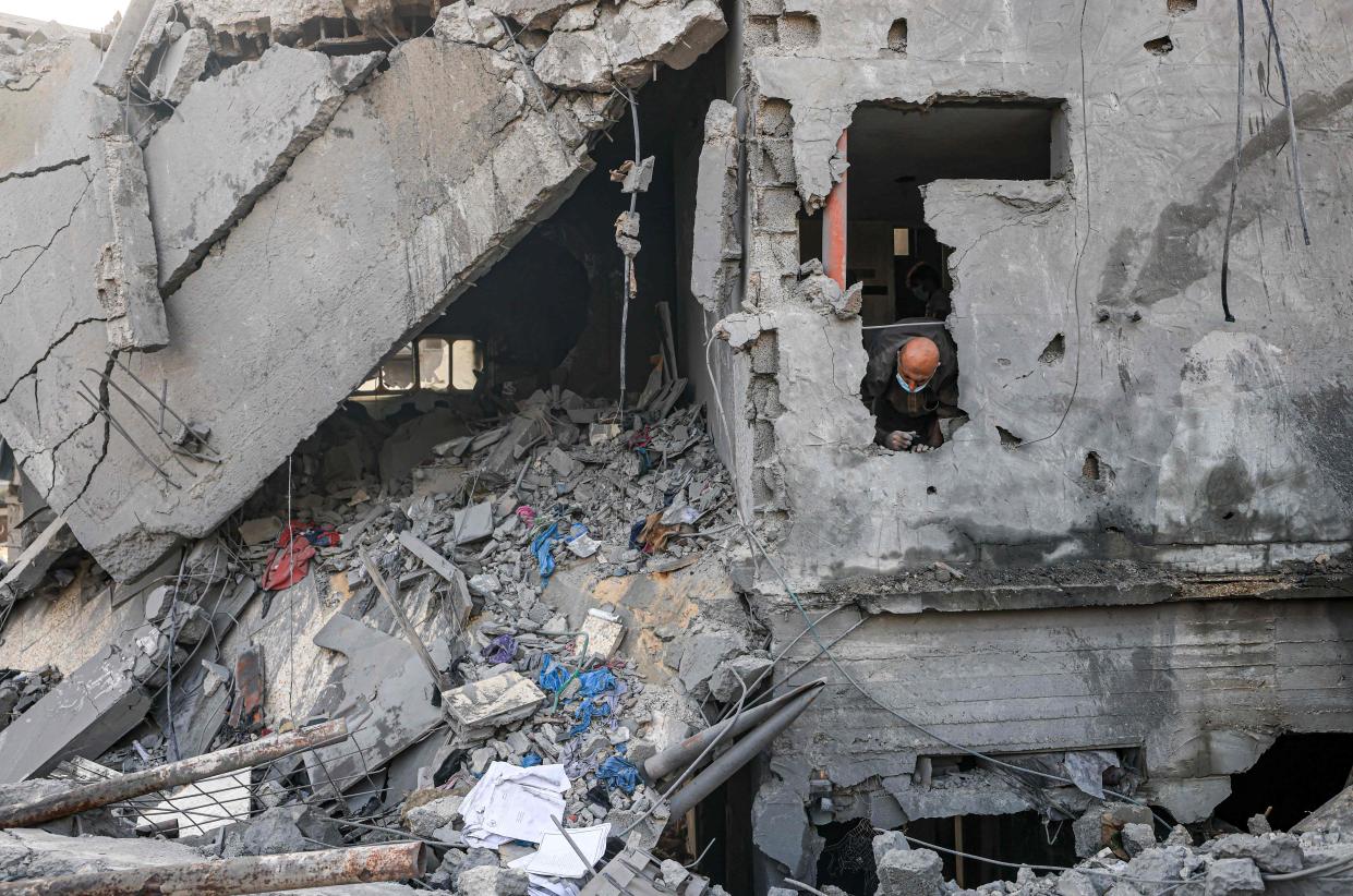 A man looks down in the search of bodies buried in rubble following Israeli airstrikes in Gaza (AFP/Getty)
