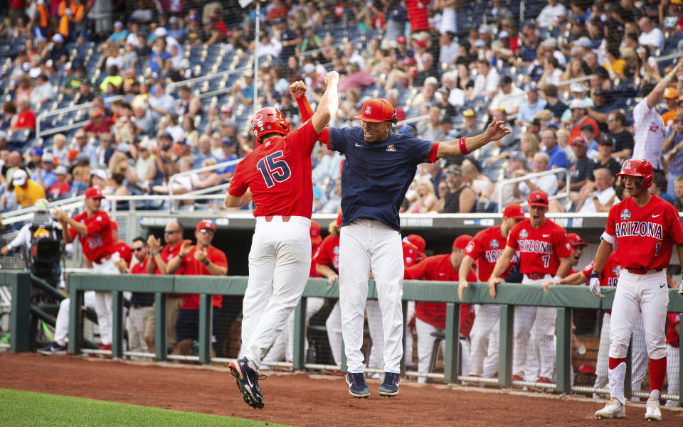 Arizona's Jacob Berry (15), left, celebrates with teammate Chase Davis (8) after scoring off a hit by Branden Boissiere (not shown) against Vanderbilt in the first inning during a baseball game in the College World Series, Saturday, June 19, 2021, at TD Ameritrade Park in Omaha, Neb. (AP Photo/Rebecca S. Gratz)