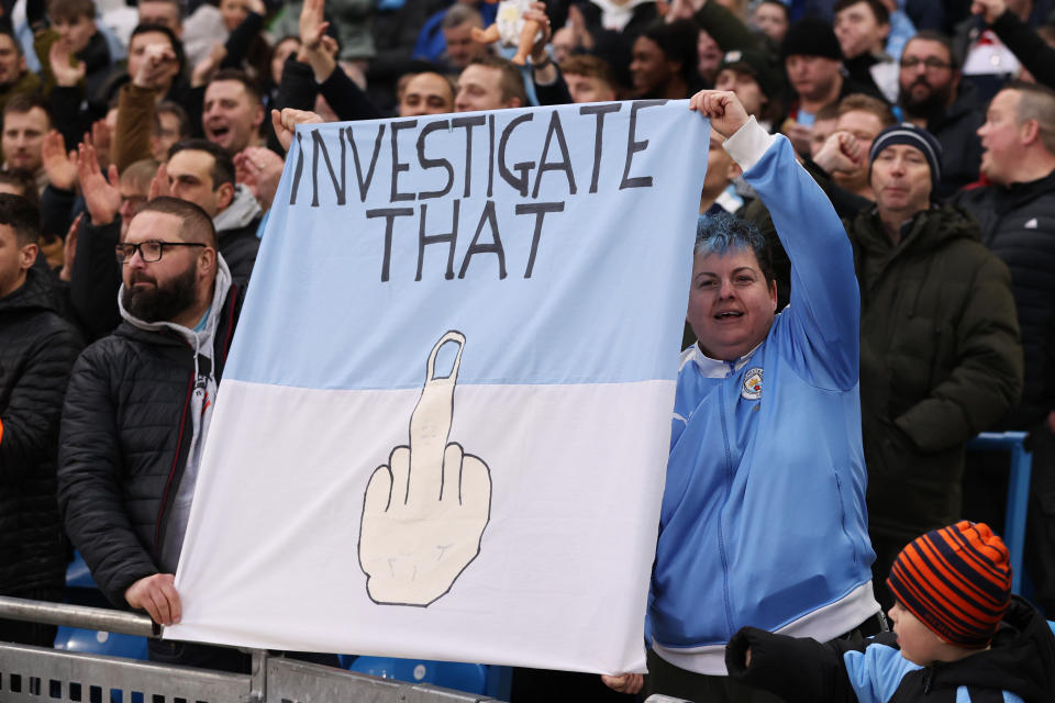 Manchester City fans hold a flag which reads 'Investigate That' prior to the Premier League match against Aston Villa.