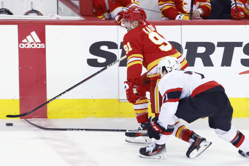 Calgary Flames' Nazem Kadri, left, keeps the puck away from Ottawa Senators' Ridly Greig during the first period of an NHL hockey game Tuesday, Jan. 9, 2024, in Calgary, Alberta. (Larry MacDougal/The Canadian Press via AP)