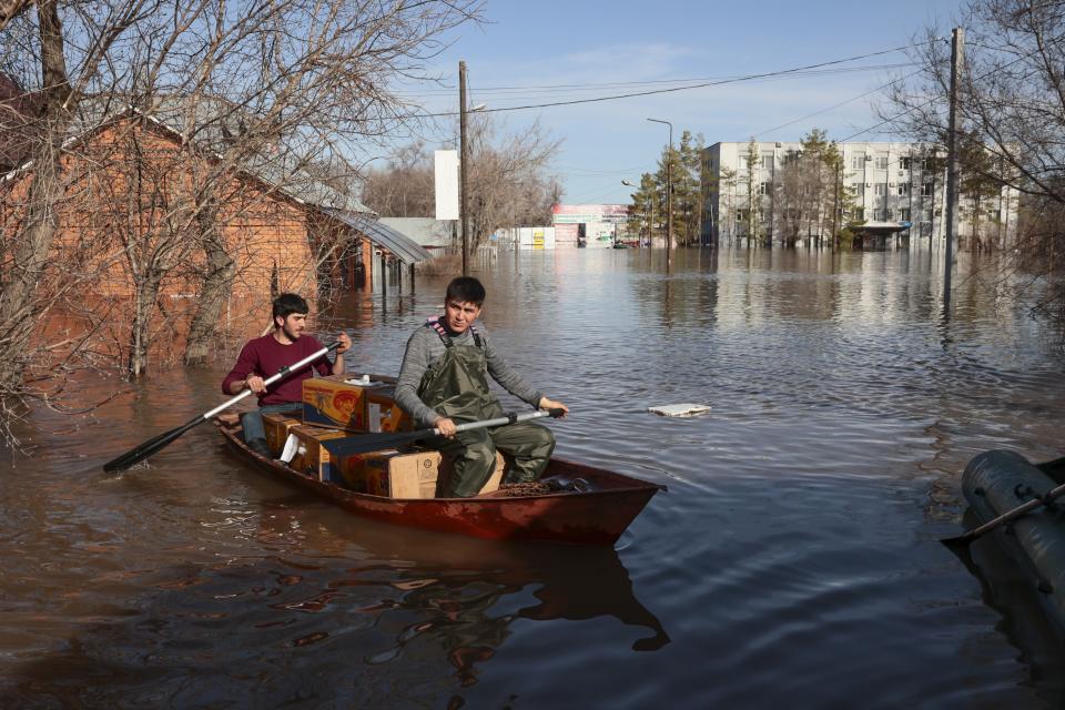 Two men ride a boat delivering food in a flooded area in Orenburg, Russia, on Thursday, April 11, 2024. Russian officials are scrambling to help homeowners displaced by floods, as water levels have risen in the Ural River. The river's water level in the city of Orenburg was above 10 meters (33 feet) Wednesday, state news agency Ria Novosti reported, citing the regional governor. (AP Photo)