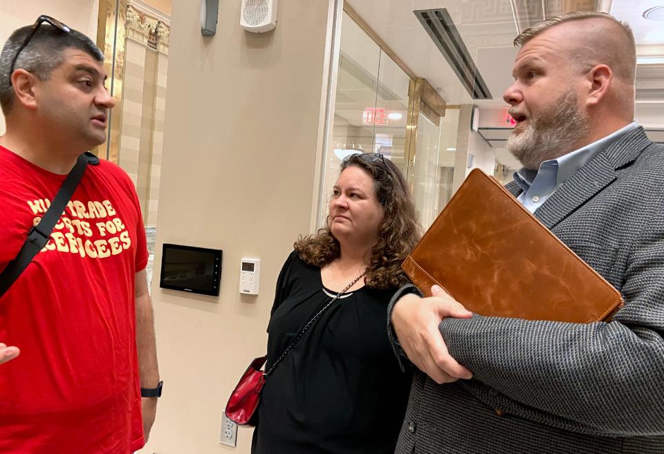 Adam Soltani, left, executive director of the Council on American-Islamic Relations-Oklahoma, talks with Afghan family sponsors Christine and Jeff Poyner after an interim study session on Tuesday at the state Capitol.