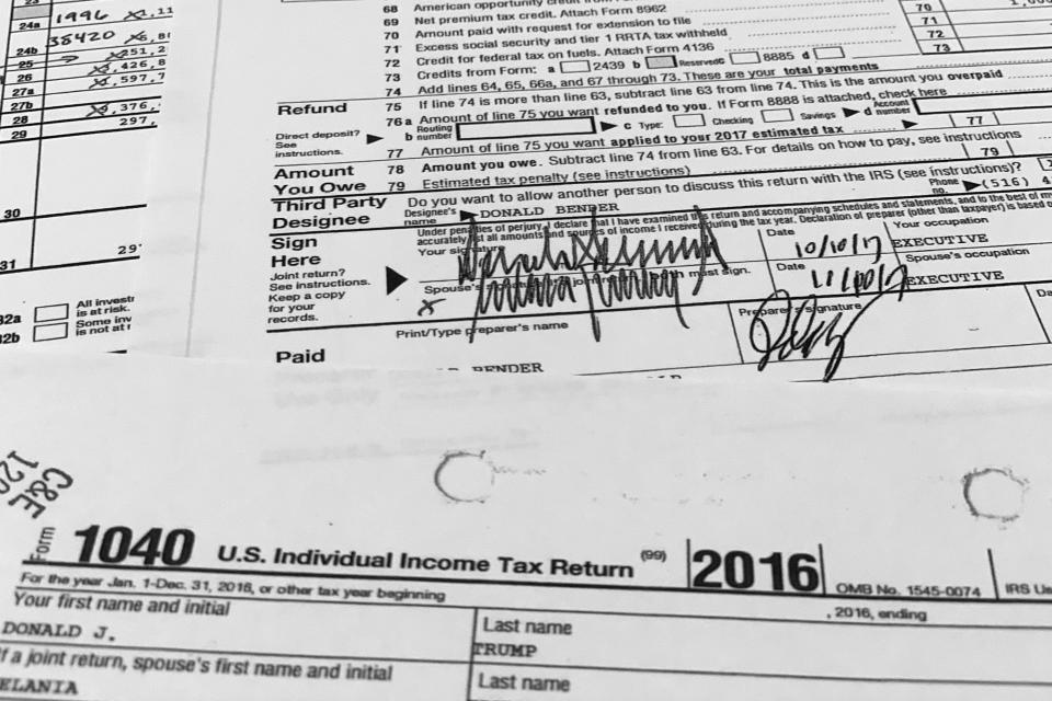 Signatures of former President Donald Trump and former first lady Melania Trump appear on their individual tax returns for 2016, released by the Democratic controlled House Ways and Means Committee, are photographed Friday, Dec. 30, 2022. The returns, which include redactions of some personal sensitive information such as Social Security and bank account numbers, span nearly 6,000 pages, including more than 2,700 pages of individual returns, and more than 3,000 pages in returns for Trump's business entities. (AP Photo/Jon Elswick)