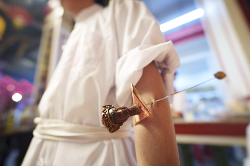 Ethnic Chinese devotees are pierced with a metal rod on their arm as they prepare for a procession during Wangkang or "royal ship" festival at Yong Chuan Tian Temple in Malacca, Malaysia, Thursday, Jan. 11, 2024. The Wangkang festival was brought to Malacca by Hokkien traders from China and first took place in 1854. Processions have been held in 1919, 1933, 2001, 2012 and 2021.(AP Photo/Vincent Thian)