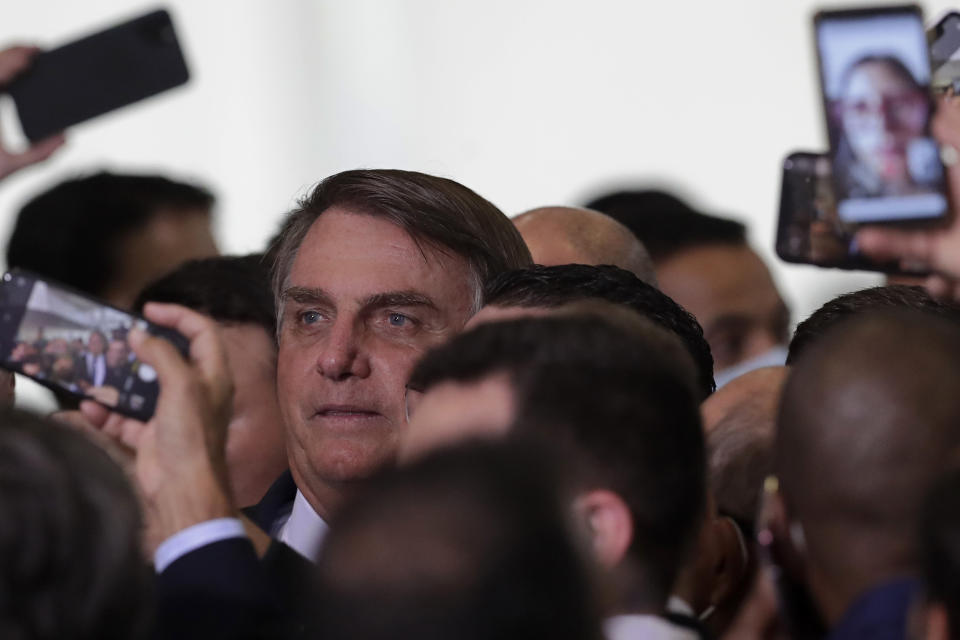 Brazil's President Jair Bolsonaro has his photo taken with newly elected mayors after a ceremony to present the government's agenda, at the Planalto Presidential Palace, in Brasilia, Brazil, Tuesday, Feb. 23, 2021. (AP Photo/Eraldo Peres)