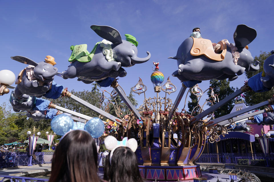 Guests ride the Dumbo ride at Disneyland in Anaheim, Calif., Friday, April 30, 2021. The iconic theme park in Southern California that was closed under the state's strict virus rules swung open its gates Friday and some visitors came in cheering and screaming with happiness. (AP Photo/Jae Hong)