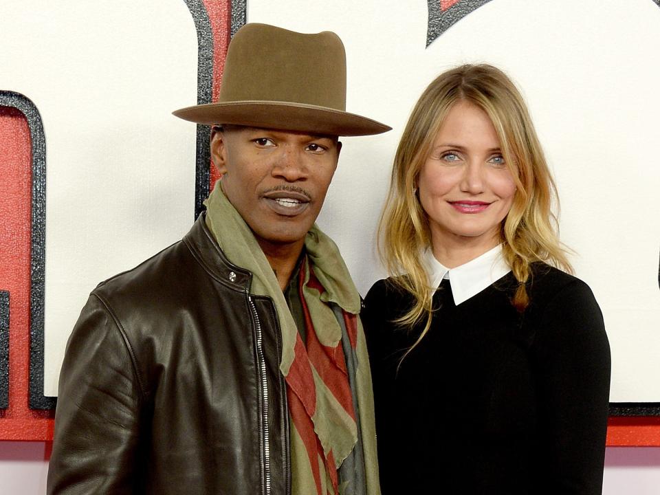 Jamie Foxx in a hat and jacket standing next to Cameron Diaz in a black sweater