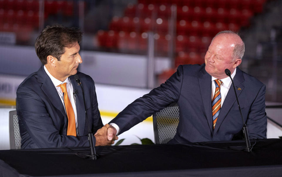 FILE - In this Monday, June 17, 2019, file photo, new Anaheim Ducks head coach Dallas Eakins, left, is introduced by general manager Bob Murray during an NHL hockey news conference in Irvine, Calif. For the teams that missed the 2020 playoffs, they've spent the past 10 months waiting for the compressed 56-game 2021 season. (Paul Bersebach/The Orange County Register via AP, File)