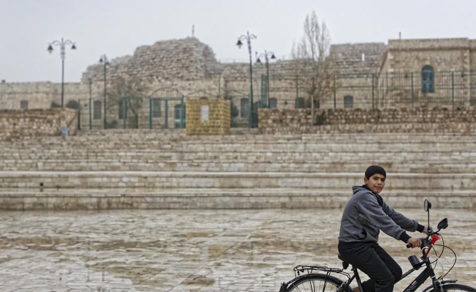 A Jordanian boy rides his bicycle in front of empty steps leading to Karak Castle in the central town of Karak, about 140 kilometers (87 miles) south of the capital Amman, in Jordan Monday, Dec. 19, 2016. Gunmen assaulted Jordanian police in a series of attacks Sunday, including at the Karak Crusader castle popular with tourists, killing seven officers, two local civilians and a woman visiting from Canada, officials said. (AP Photo/Ben Curtis)