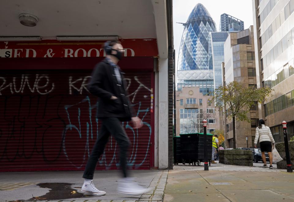 A man wearing a protective face covering to combat the coronavirus walks past a closed shop in central London on November 10, 2020. - Britain's unemployment rate has jumped to 4.8 percent as the coronavirus pandemic destroys a record number of UK jobs, official data showed Tuesday. (Photo by Tolga Akmen / AFP) (Photo by TOLGA AKMEN/AFP via Getty Images)