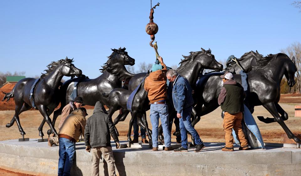 Workers on Jan. 11 install the "Valle del Caballo,"(Valley of the Horse) bronze statue by sculptor by Paul Moore in Edmond. The $650,000 sculpture was obtained by Edmond through its art in public places program administered by its visual arts commission. Officials say $470,000 used to buy the statue was provided by private donors.