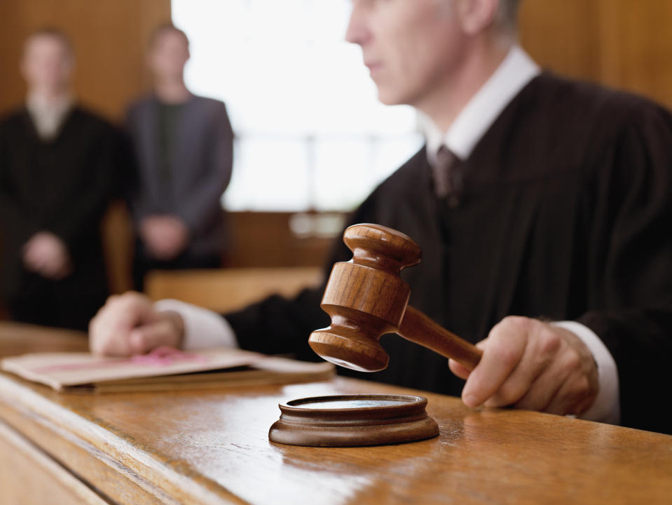 A judge holding a gavel in a courtroom