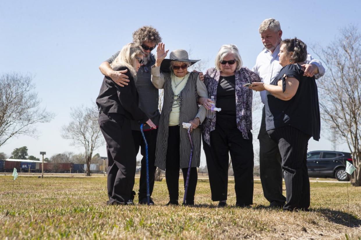 From left, Debbie Brooks, Christopher Casasanta, Donna Casasanta, Cheryl Clouse, Les Linn and Tess Welch embrace and pray March 1 at the gravesite of their loved ones, Harold Dean Clouse and his wife, Tina Gail Linn, in Houston. The couple's bodies had been found in 1981, but only identified by DNA testing last year.