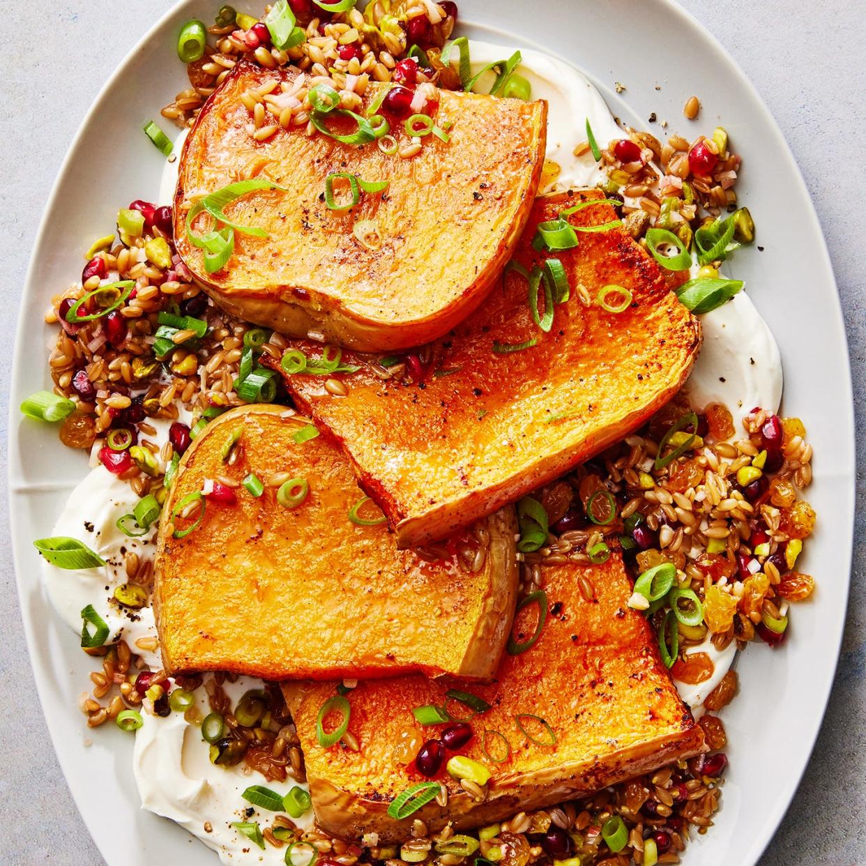 butternut squash steaks with creamy yogurt and farro and pomegranates on a plate