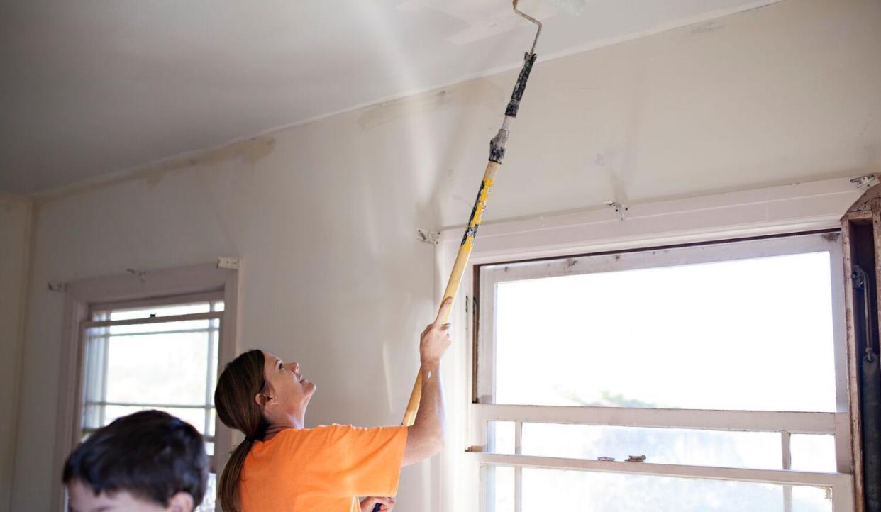 woman painting ceiling