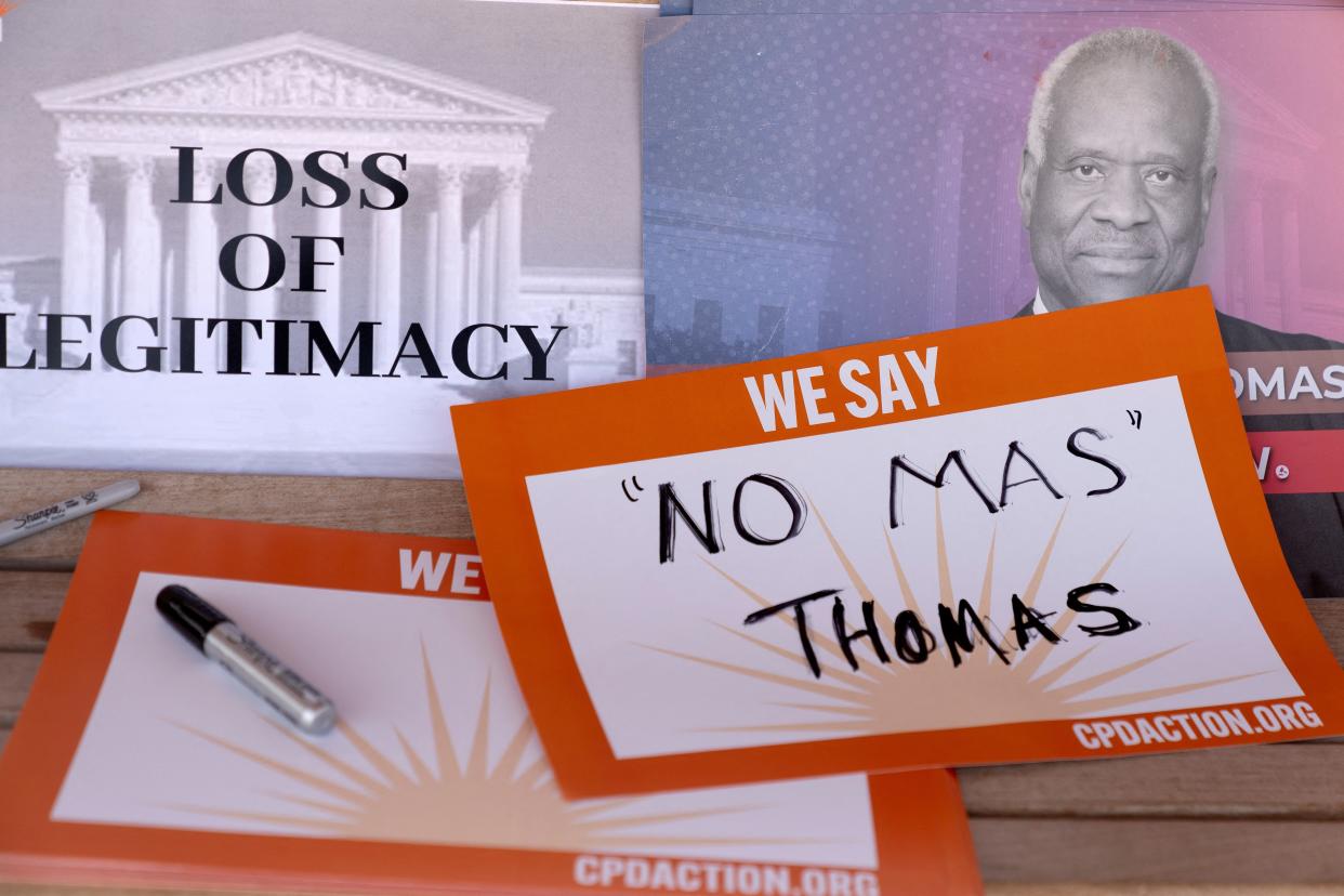 Signs calling on Justice Clarence Thomas to resign are seen on Capitol Hill. One sign reads: Loss of legitimacy. Another sign reads: No mas Thomas.