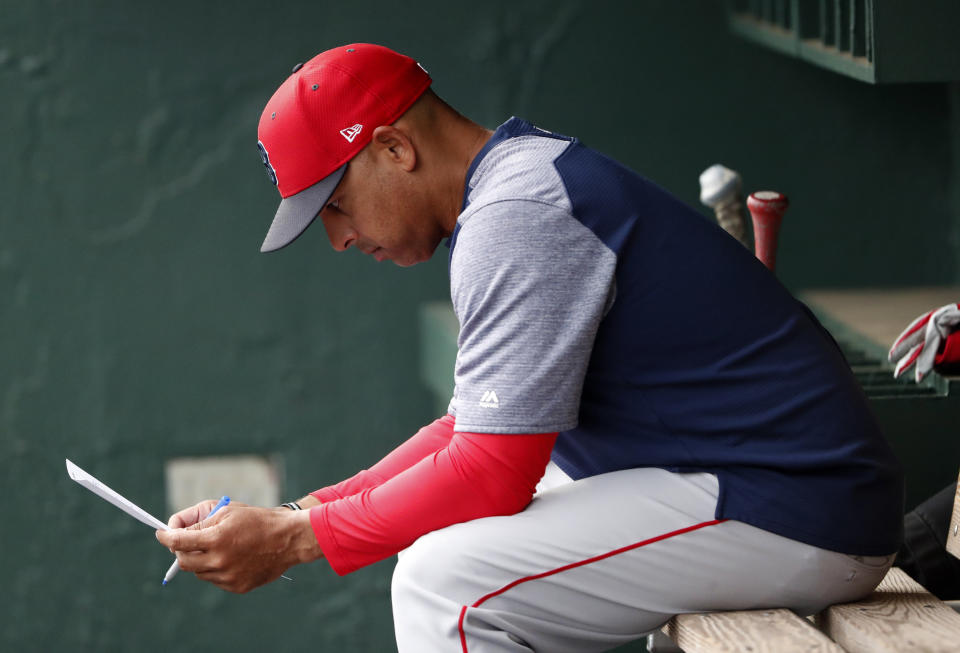 FILE - In this March 20, 2019, file photo, Boston Red Sox manager Alex Cora looks over the lineup before the team's spring training baseball game against the Baltimore Orioles in Sarasota, Fla. Cora was fired by the Red Sox on Tuesday, Jan. 14, 2020, a day after baseball Commissioner Rob Manfred implicated him in the sport's sign-stealing scandal. (AP Photo/John Bazemore)