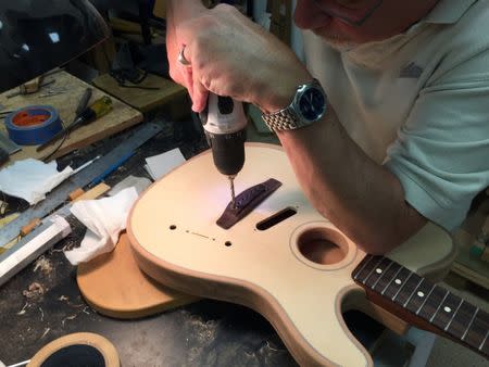 FILE PHOTO: Fender Musical Instruments CorporationÕs Tim Shaw drills a bridge in one of the companyÕs new American Acoustasonic Series Telecaster guitars in Corona, California, U.S., in this photo provided January 18, 2019. Fender Musical Instruments Corp/Handout via REUTERS