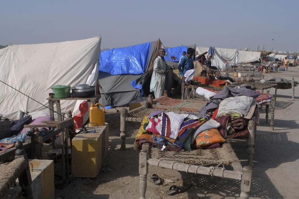 Displaced families who fled their flood-hit homes take refuge along a roadside in Jamshoro, southern Sindh province, Pakistan, Friday, Sept. 16, 2022. The devastating floods affected over 33 million people and displaced over half a million people who are still living in tents and make-shift homes. The water has destroyed 70% of wheat, cotton and other crops in Pakistan. (AP Photo/Pervez Masih)