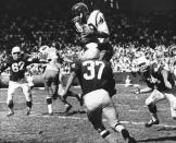 FILE - In this Oct. 15, 1962, file photo, Bobby Mitchell, of the Washington Redskins, jumps to haul in a pass from quarterback Norman Snead in the second period of their NFL football game against the St. Louis Cardinals in St. Louis. Mitchell, the speedy late 1950s and ’60s NFL offensive star the Cleveland Browns and the Redskins, has died. He was 84. The Pro Football Hall of Fame said Sunday night, April 5, 2020, that Mitchell’s family said he died in the afternoon. (AP Photo/Fred Waters, File)