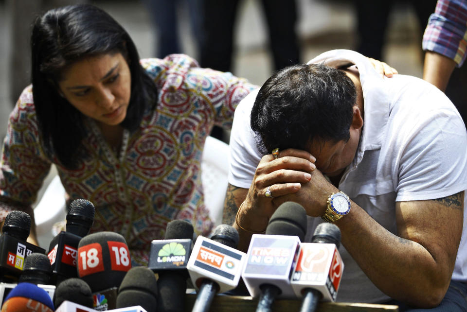 Indian Bollywood actor Sanjay Dutt, right, breaks down as his sister Priya Dutt tries to console him during a press conference at his residence in Mumbai, India, Thursday, March 28, 2013. Dutt says he has not sought pardon for a 1993 weapons conviction and will serve his prison sentence as ordered by India's Supreme Court. Dutt broke his silence a week after the court sentenced him to five years in prison for illegal possession of weapons supplied by Mumbai crime bosses linked to a 1993 terror attack that killed 257 people.(AP Photo/Rafiq Maqbool)