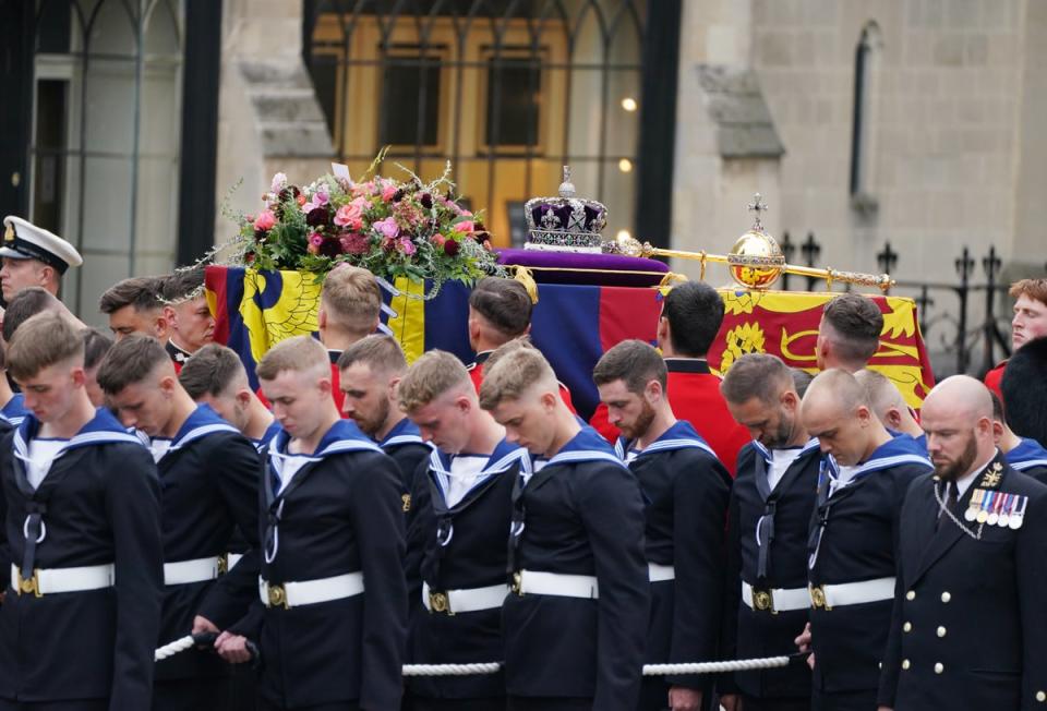 The coffin of Queen Elizabeth II, draped in the Royal Standard with the Imperial State Crown and the Sovereign’s orb and sceptre, is carried into Westminster Abbey (Andrew Milligan/PA) (PA Wire)