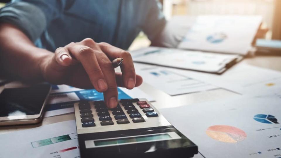 Business accounting concept, Business man using calculator with computer laptop, budget and loan paper in office.