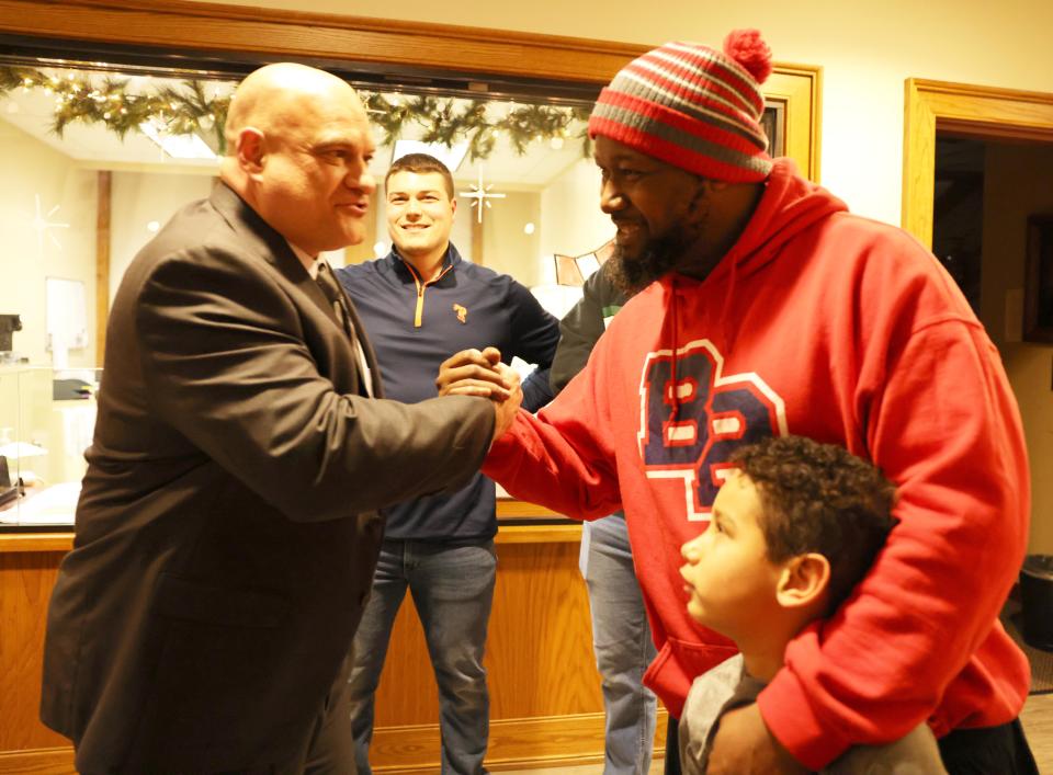 Raynham Police Det. Louis F. Pacheco, left, is congratulated by Lamont Penn at Town Hall on Tuesday, Jan. 23, 2024. Selectmen presented the Raynham Recognition Award to Pacheco, who is the Raynham school resource officer and B-R head football coach.