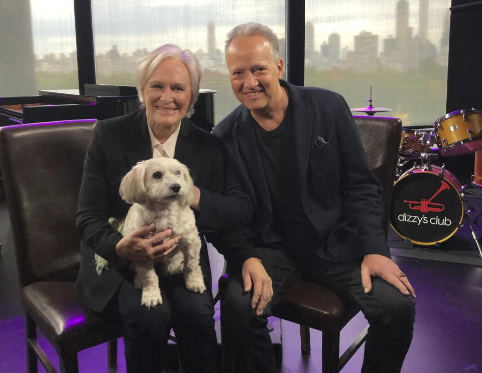 Actress-singer Glenn Close holds Pip as she poses with Ted Nash at Jazz at Lincoln Center’s Dizzy’s Club in New York on Nov. 7, 2019. On Friday the pair are releasing “Transformation: Personal Stories of Change, Acceptance, and Evolution,” an 11-track spoken word jazz album that tackles heavy topics like race, politics and identity. (Madelyn Gardner via AP)