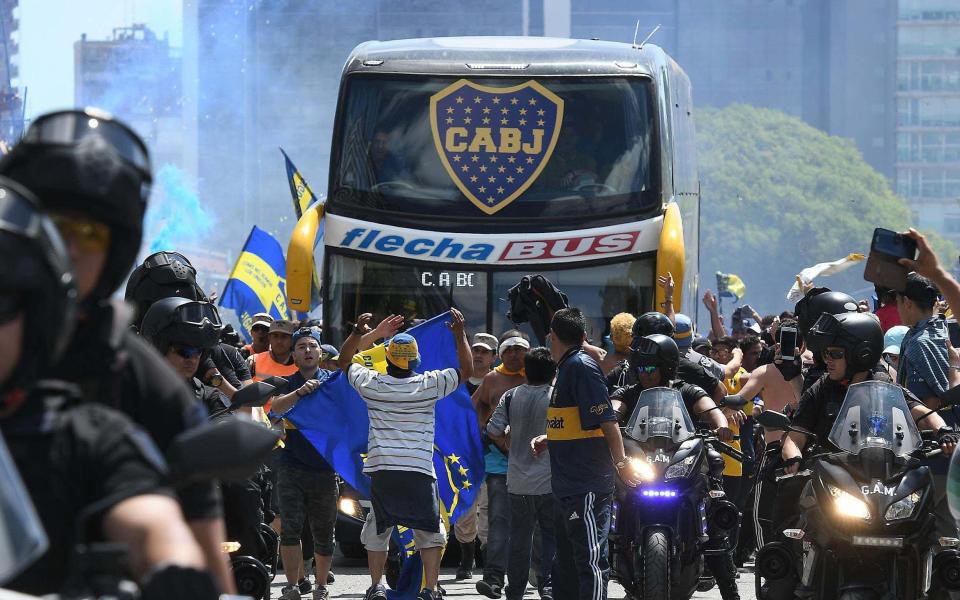 An attack on the Boca Juniors bus by rival fans which left players suffering cuts from broken glass and feeling the effects of tear gas has led to the postponement of the second leg of their Copa Libertadores final at River Plate.