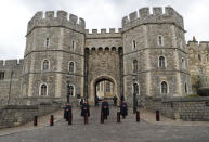 The King Henry VIII gate at Windsor Castle Windsor, England, Tuesday, April 13, 2021, guarded by armed police and casket wardens. Britain's Prince Philip, husband of Queen Elizabeth II, died Friday April 9 aged 99. His funeral service will take place on Saturday at Windsor Castle. (AP Photo/Alastair Grant)