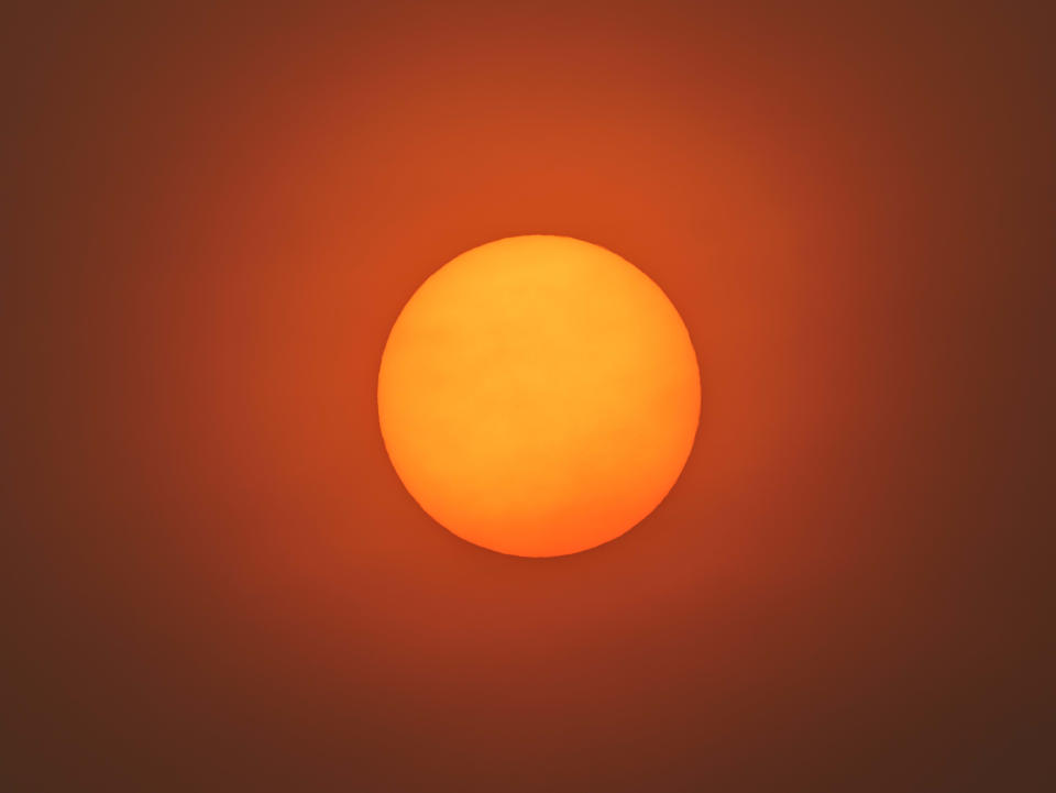 Smoke and ash particles creating eerie sun glow in San Francisco Bay Area.