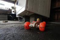 A small "Speed Racer" toy covered with residue from Pearl River flooding sits on the floor adjacent to a dryer boosted on blocks to prevent water damage in this Jackson, Miss., home, Wednesday, Feb. 19, 2020. Many flood affected residents have started cleanup as some houses have little or no floodwater damage to several feet. (AP Photo/Rogelio V. Solis)