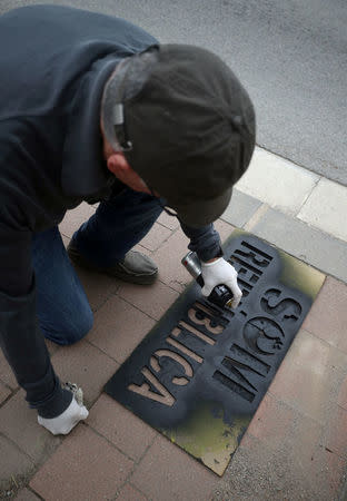 A member of Granoller's Committee for the Defence of the Republic (CDR) spray paints a slogan reading "We are a Republic" as part of an protest to demand the release of jailed Catalonian politicians in Granollers, Spain May 12, 2018. REUTERS/Albert Gea