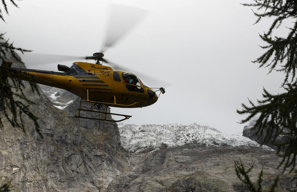 FILE - A helicopter flies over the Planpincieux glacier located in the Alps on the Grande Jorasses peak of the Mont Blanc massif, above the Val Ferret, near Courmayeur, northern Italy, Sept. 25, 2019. As glaciers melt and pour massive amounts of water into nearby lakes, 15 million people across the globe live under the threat of a sudden and deadly outburst flood, a new study finds. (AP Photo/Antonio Calanni, File)