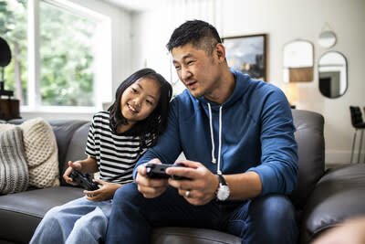 Using the latest & greatest tech, a father and daughter play video games together (CNW Group/Best Buy Canada Ltd.)