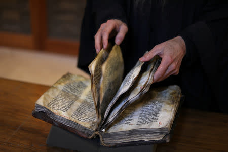 Librarian, Father Justin of Sinai, turns pages of a manuscript in the library of St. Catherine's Monastery in South Sinai, Egypt, March 6, 2019. REUTERS/Mohamed Abd El Ghany