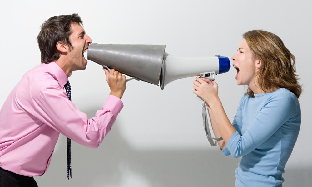 Man and woman shouting at each other through megaphones