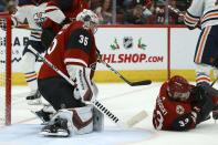 Arizona Coyotes goaltender Darcy Kuemper (35) makes a save against the Edmonton Oilers as Coyotes defenseman Alex Goligoski (33) dives to protect the net during the second period of an NHL hockey game Sunday, Nov. 24, 2019, in Glendale, Ariz. (AP Photo/Ross D. Franklin)