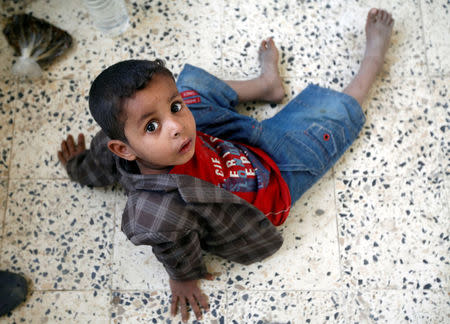 A displaced boy from Hodeidah city sits on the floor at a school where displaced people live, in Sanaa, Yemen June 22, 2018. REUTERS/Mohamed al-Sayaghi