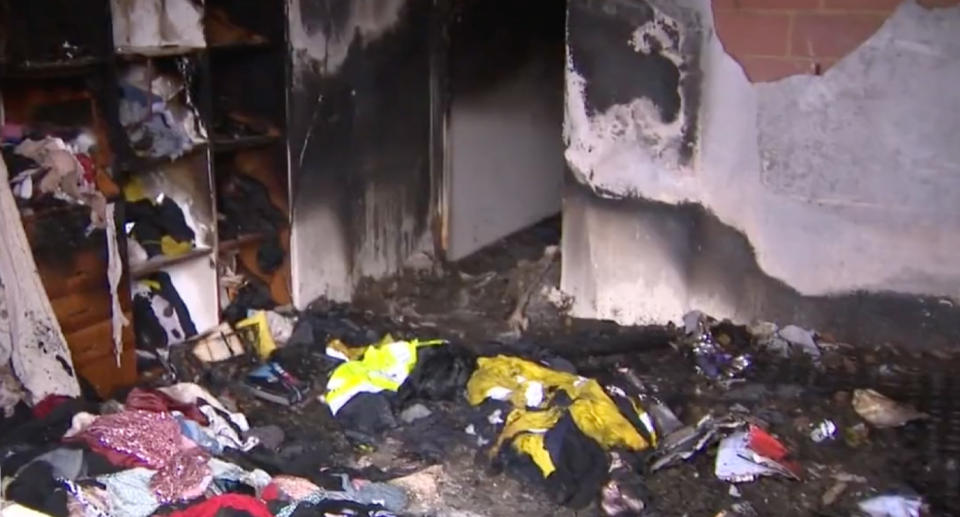 The master bedroom can be seen with smoke damaged clothes strewn everywhere. 