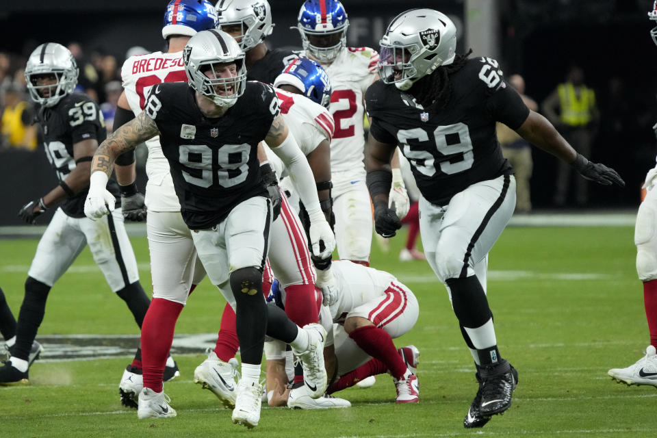 Las Vegas Raiders defensive tackle Adam Butler (69) and Las Vegas Raiders defensive end Maxx Crosby celebrate a sack against the New York Giants during the second half of an NFL football game, Sunday, Nov. 5, 2023, in Las Vegas. (AP Photo/Rick Scuteri)