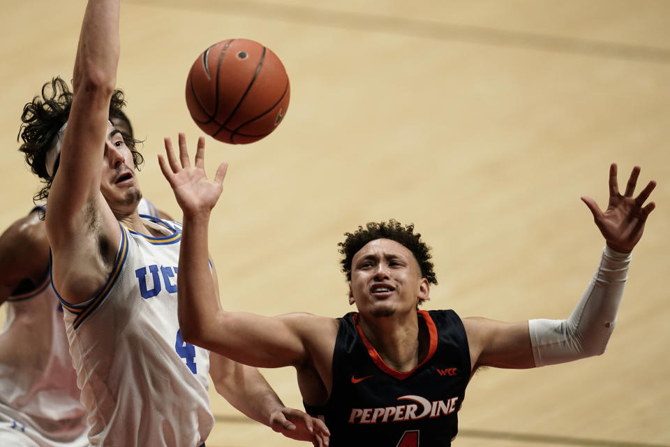 Pepperdine guard Colbey Ross, right, loses the ball as UCLA guard Jaime Jaquez Jr., left, defends during the second half of an NCAA college basketball game Friday, Nov. 27, 2020, in San Diego. (AP Photo/Gregory Bull)