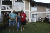 Ron Sambrano, Tamara Akiona and Kawehi Akiona stand in the Akiona’s backyard on July 12, 2024, in Wailuku, Hawaii. Sambrano is Tamara Akiona’s uncle. After the family’s home was burned in the Lahaina wildfire, she took him into her newly bought condominium, and later enrolled in the nonprofit Council for Native Hawaiian Advancement’s Host Housing Support Program, which offers cash assistance for housing displaced wildfire survivors. (AP Photo/Manuel Valdes)