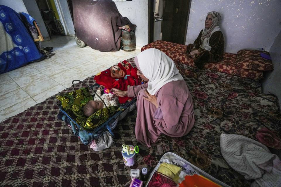 CORRECTS LOCATION - Rola Saqer plays with her baby Masa Mohammad Zaqout at her parents' home in the neighborhood of Zawaida, central Gaza, Thursday, April 4, 2024. Zaqout was born Oct. 7, the day the Israel- Hamas war erupted. Mothers who gave birth in the Gaza Strip that day fret that their 6-month-old babies have known nothing but brutal war, characterized by a lack of baby food, unsanitary shelter conditions and the crashing of airstrikes. (AP Photo/Abdel Kareem Hana)